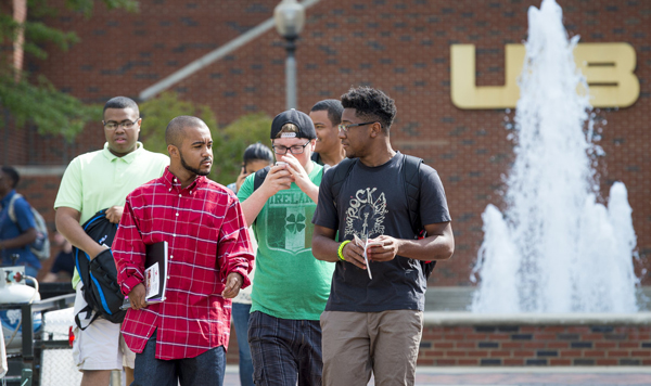 Students walking near a campus fountain. 