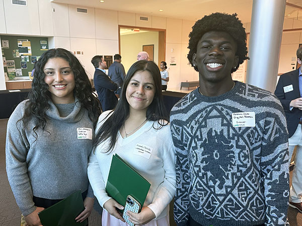 Three students smiling at the camera