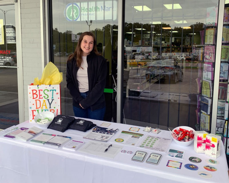 Volunteer at a table outside a store. 