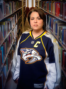 Rebecca Dobrinski, in a hockey jersey, at the library. 