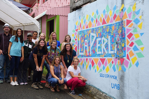 DFLL students in PuertoRico, 2016, posing next to a brightly colored La Perla mural. 