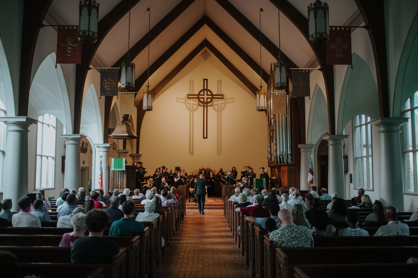 A dramatic picture of the choir performing in the full church with audience in the pews.