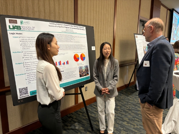 Jade Kim and Suyeon Kim presenting their poster to Interim Dean Geurs