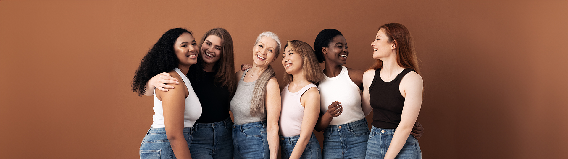 Cheerful women of different body types and ages standing together in studio.