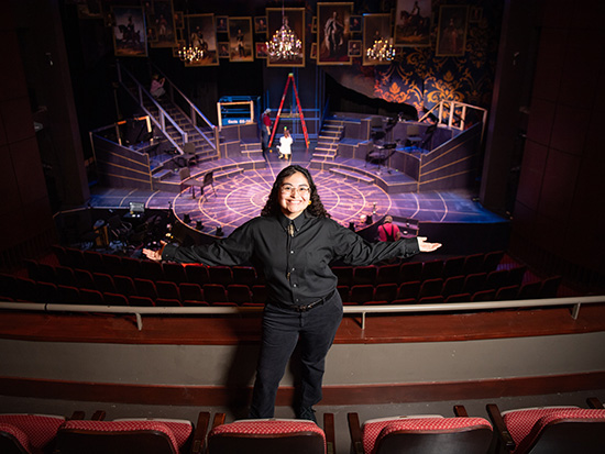 Girl standing infront of theatre seats showing off the set