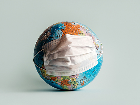 Globe made of jigsaw puzzles with a protective medical mask as a prophylaxis in the fight against coronavirus infection. Measures against the spread of the virus