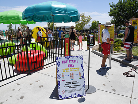 HENDERSON, NEVADA - MAY 30:  A sign asking guests to practice social distancing is posted at the entrance to a slide at Cowabunga Bay Water Park, which was allowed to open for the first time this weekend because of the coronavirus (COVID-19) pandemic on May 30, 2020 in Henderson, Nevada. The park would have opened on March 21 but had to wait until Nevada's Phase Two reopening of the economy, which includes operating at 50% capacity, new social distancing guidelines and other restrictions in place. As a thank you for waiting for the reopening, the park is only allowing season pass holders in on opening weekend; it opens to the public on June 1.  (Photo by Ethan Miller/Getty Images)
