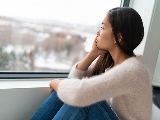 Girl feeling lonely looking out the window. 