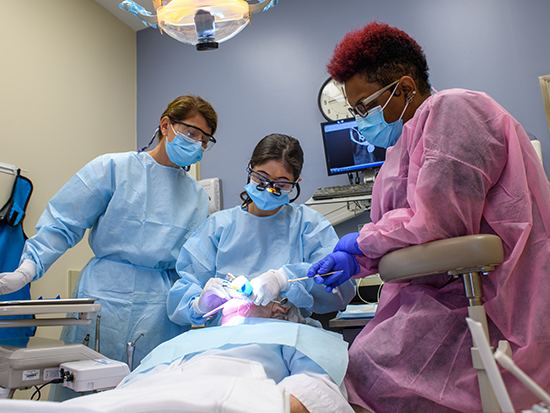 UAB School of Dentistry professor assists dentistry resident who is providing care to patient.