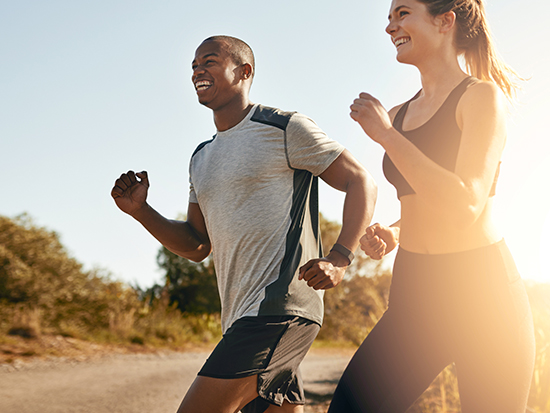 Smile, running and health with couple in road for workout, cardio performance and summer. Marathon, exercise and teamwork with black man and woman runner in nature for sports, training and race.