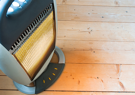 A halogen or electric heater on wooden floor