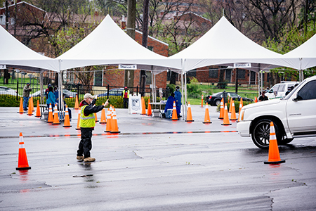 From side, man wearing a safety vest is directing traffic into the Downtown COVID-19 Testing Site for the novel coronavirus sponsored by UAB Medicine and the Jefferson County Department of Health on March, 23, 2020.