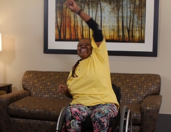 Black woman in wheelchair lifting weights. 