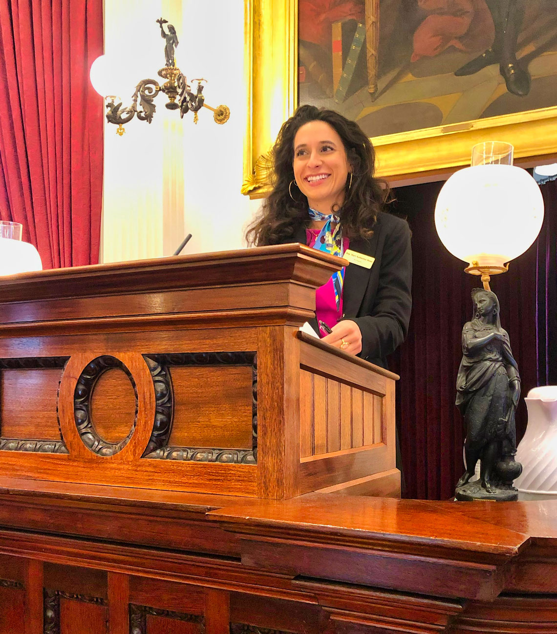  Stone stands at an ornate wooden podium with ornate lanterns. 