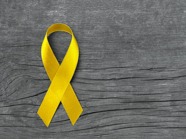 A yellow ribbon on an ashy wood background. 