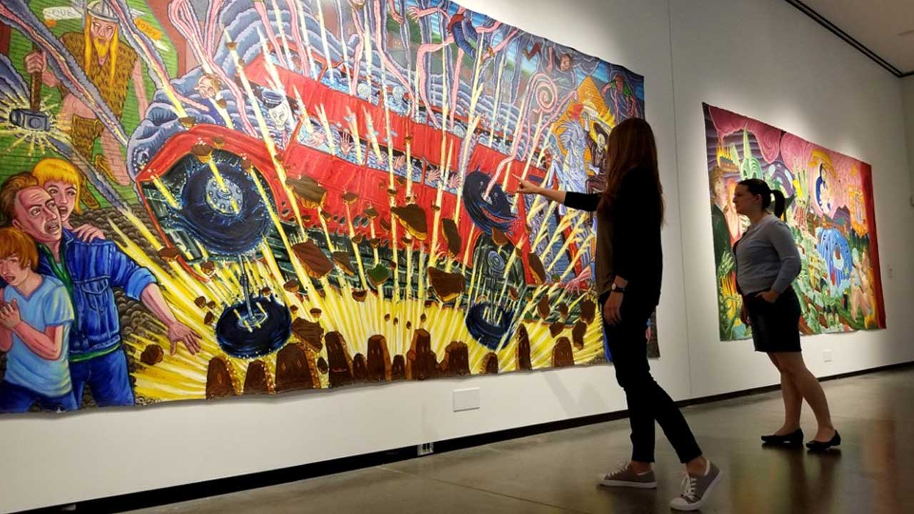 Photo: Two women observing art at the AEIVA gallery